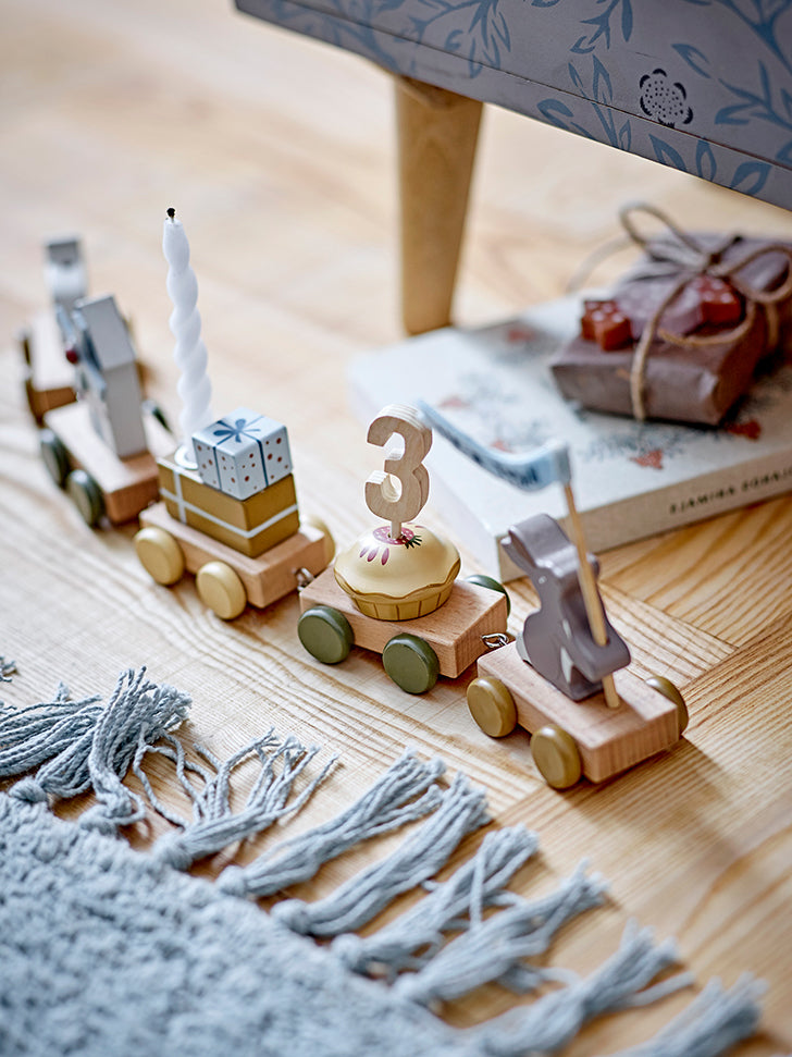 Birthday train made of wood in subdued colors, decorated with presents, animals, gifts, the number 3 and a candle