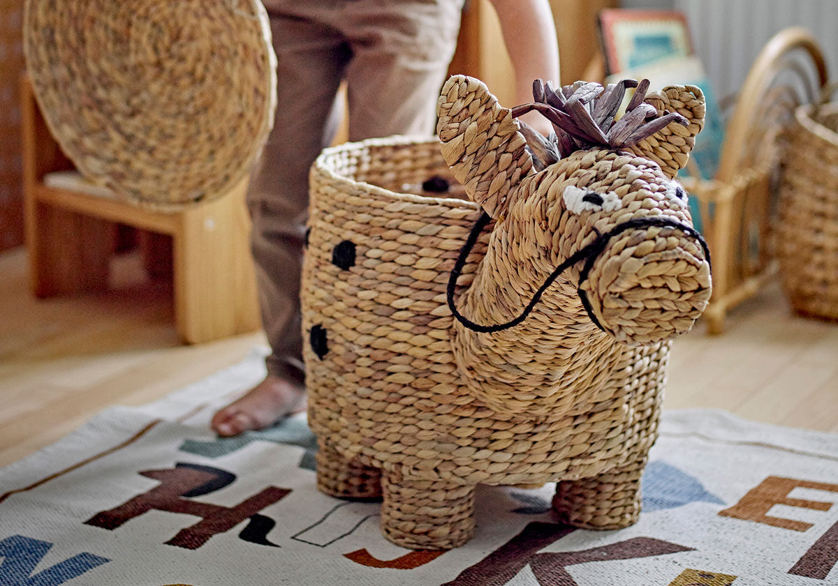 A basket made of seagrass shaped as a horse placed in a children's room