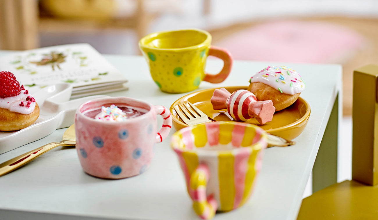 Cute colorful cups with stripes and dots placed on a table