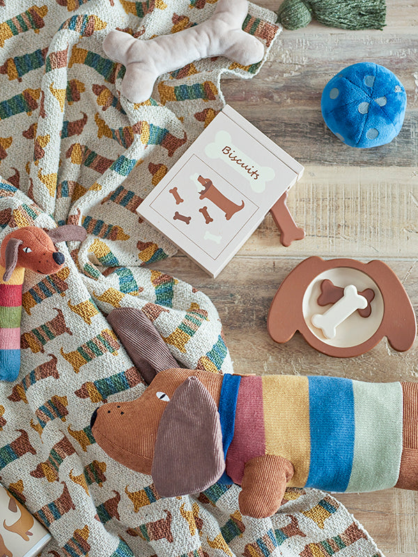 Plush toy shaped like a dog with a brown "fur" and a striped shirt