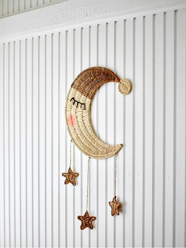 Rattan wall decor shaped as a moon with rattan stars hanging underneath